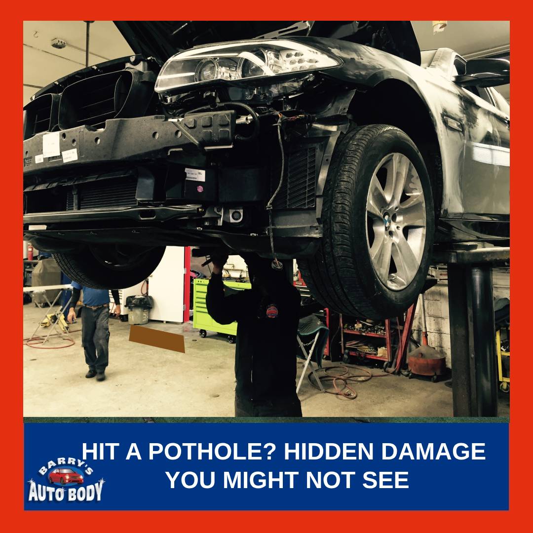 Close-up of a vehicle tire and technician inspecting the suspension system after hitting a pothole