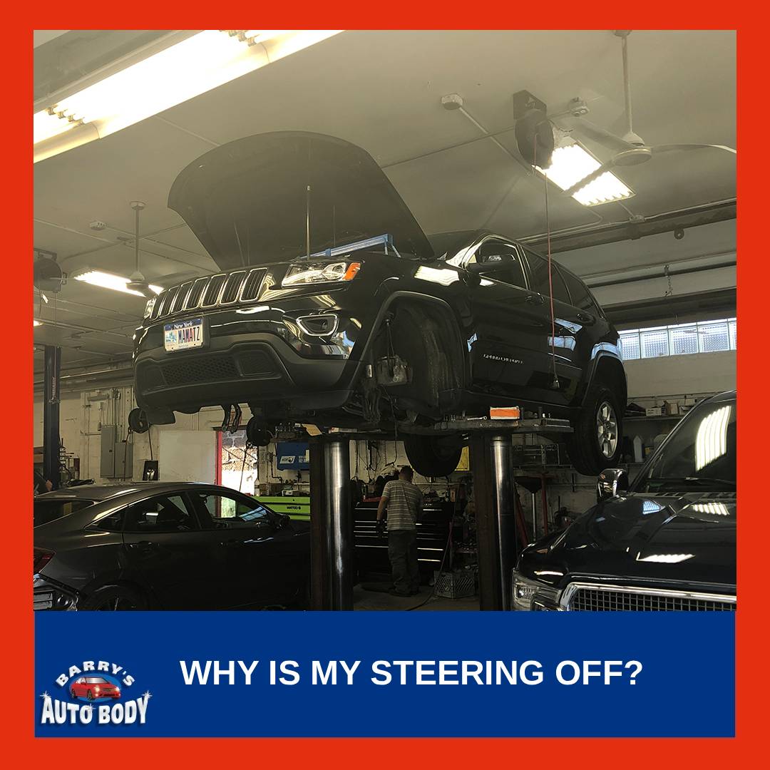 Vehicle driving on a straight road with steering wheel slightly off-center due to wheel alignment issues.
