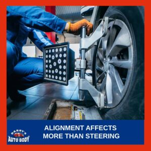 Technician performing a four-wheel alignment on a vehicle using computerized alignment equipment.